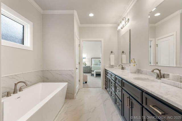 bathroom featuring recessed lighting, a sink, a freestanding tub, and a wealth of natural light