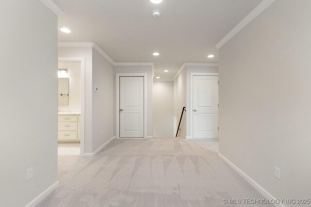 corridor with crown molding, baseboards, recessed lighting, and light colored carpet
