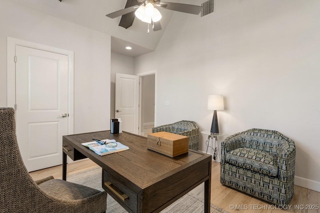 office space with high vaulted ceiling, a ceiling fan, baseboards, wood finished floors, and visible vents