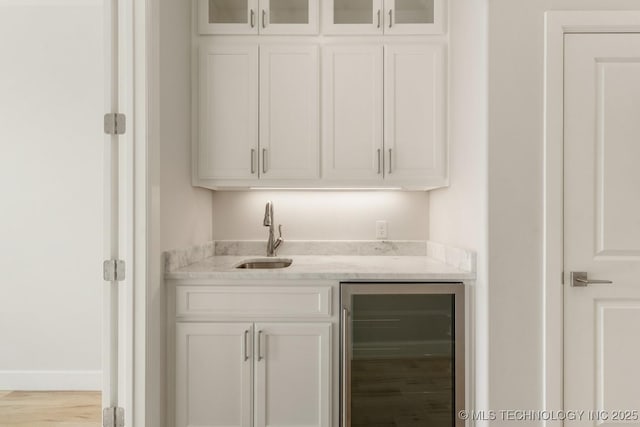 bar with wine cooler, wet bar, a sink, and wood finished floors