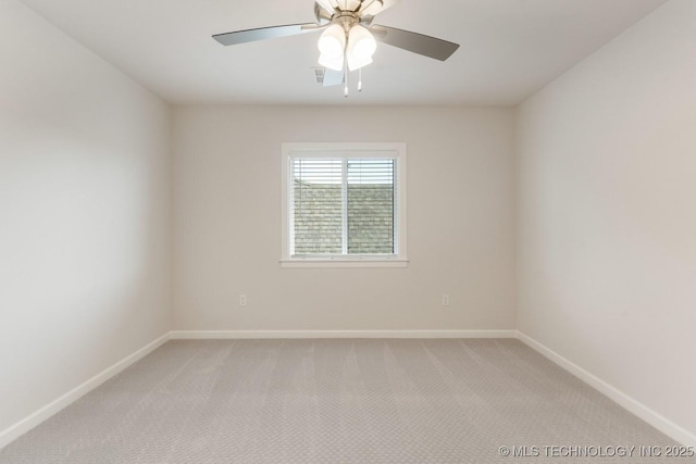 unfurnished room with light colored carpet, a ceiling fan, and baseboards