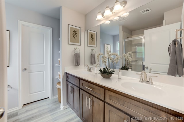 bathroom featuring hardwood / wood-style floors, vanity, and walk in shower