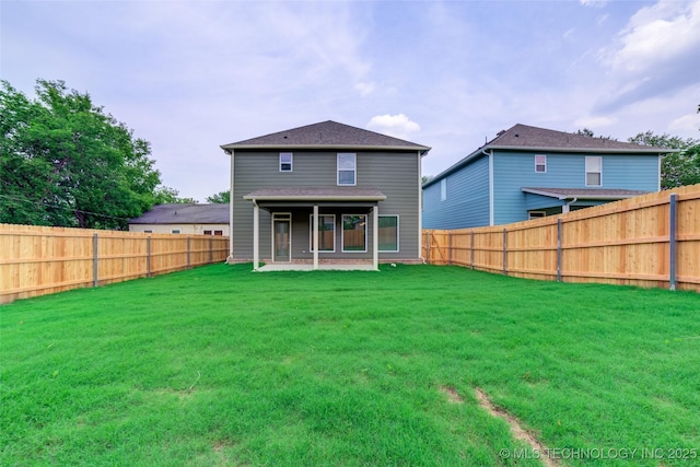 rear view of property featuring a lawn and a patio