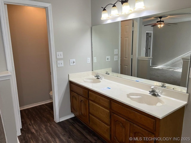 bathroom featuring wood-type flooring, vanity, toilet, and ceiling fan