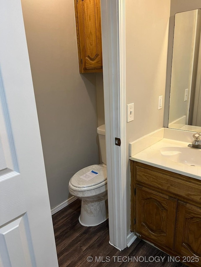 bathroom featuring vanity, hardwood / wood-style flooring, and toilet