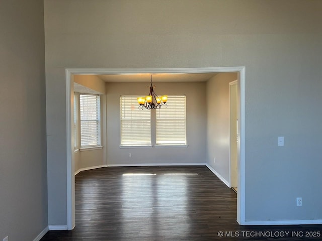 unfurnished dining area with dark wood-type flooring and a chandelier