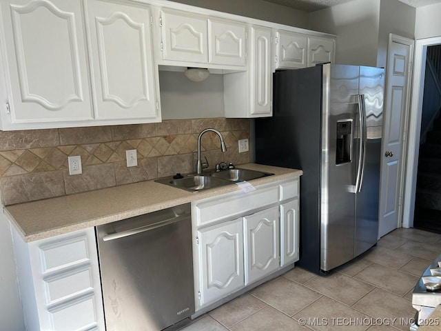 kitchen with white cabinetry, sink, light tile patterned floors, and stainless steel appliances