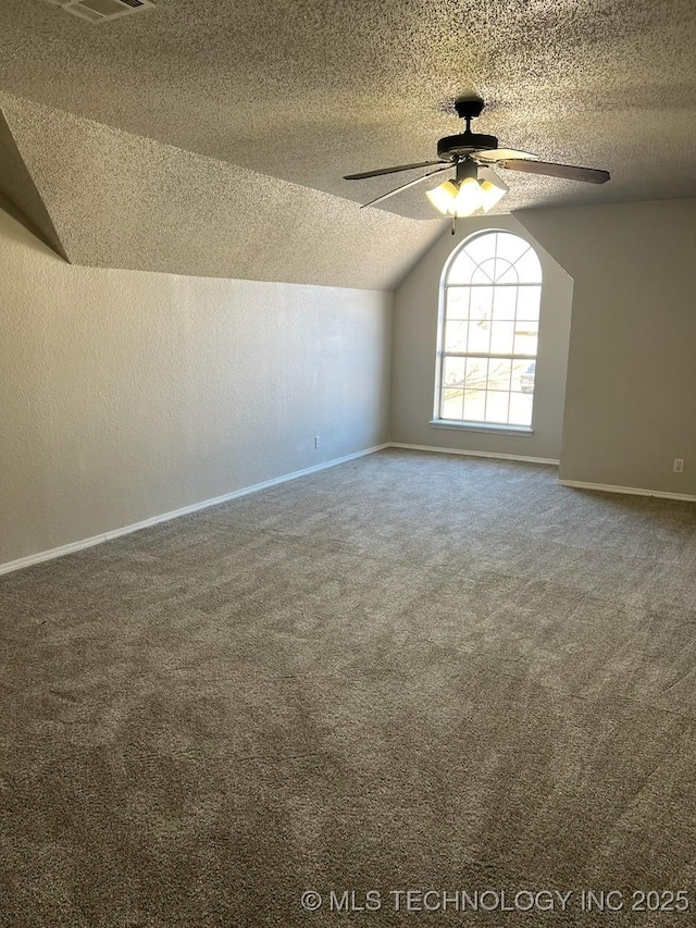 carpeted empty room with ceiling fan and lofted ceiling