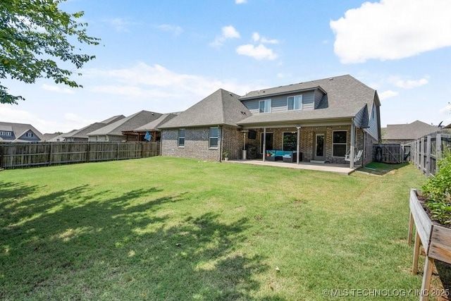 back of property with a lawn and a patio area