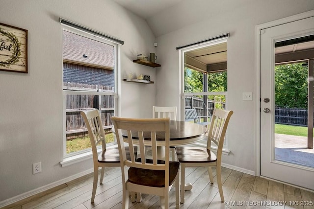 dining space with lofted ceiling and light wood-type flooring