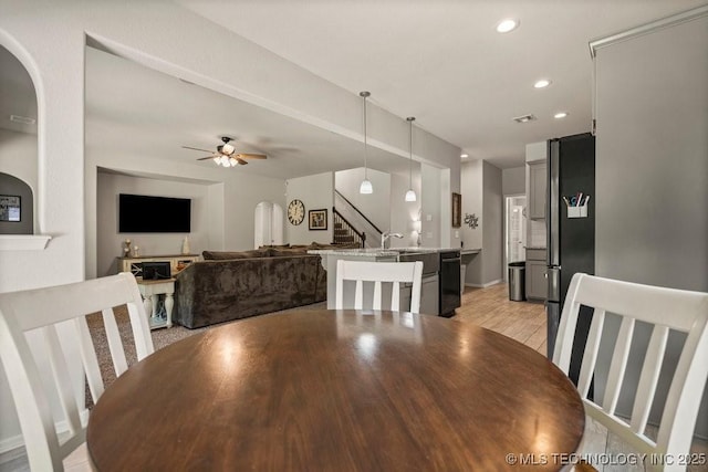 dining space featuring light hardwood / wood-style flooring, ceiling fan, and sink