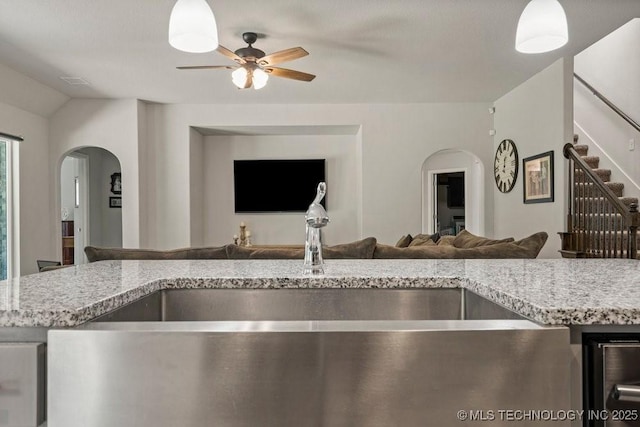 kitchen featuring ceiling fan, light stone countertops, beverage cooler, and lofted ceiling