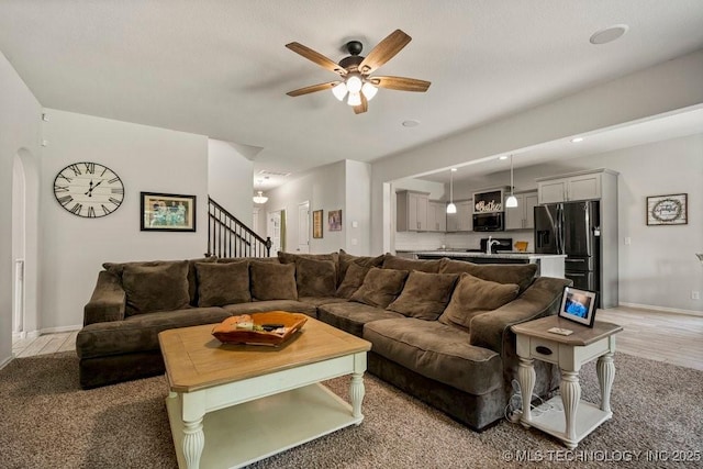 carpeted living room featuring ceiling fan