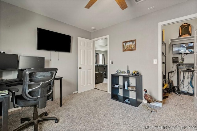 carpeted office space featuring ceiling fan