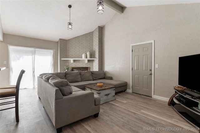 living room featuring a fireplace, lofted ceiling with beams, and light hardwood / wood-style flooring