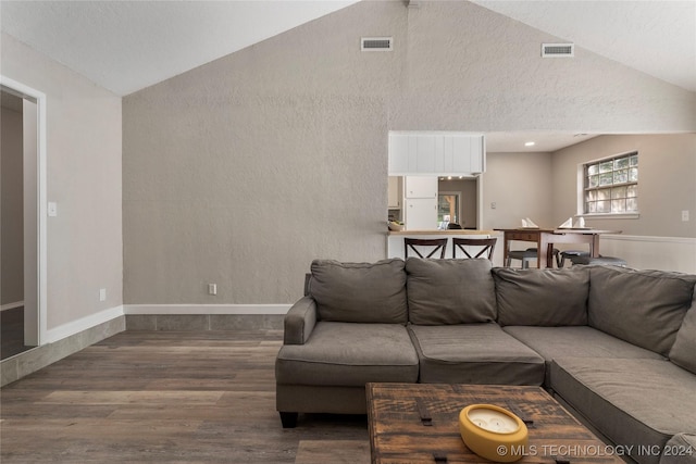 living room with wood-type flooring and vaulted ceiling