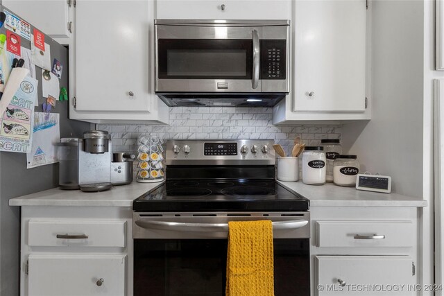 kitchen featuring decorative backsplash, white cabinetry, and appliances with stainless steel finishes