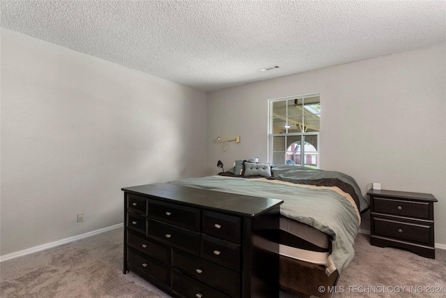 carpeted bedroom featuring a textured ceiling