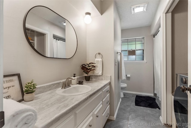 bathroom with vanity, a textured ceiling, and toilet