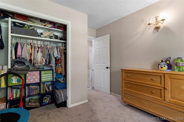 carpeted bedroom featuring a closet and a textured ceiling