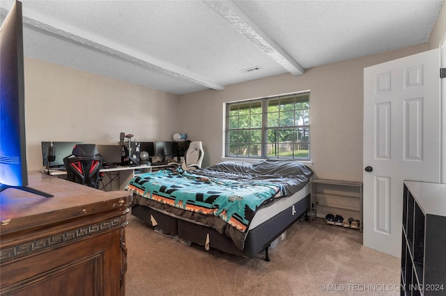 carpeted bedroom featuring beamed ceiling and a textured ceiling