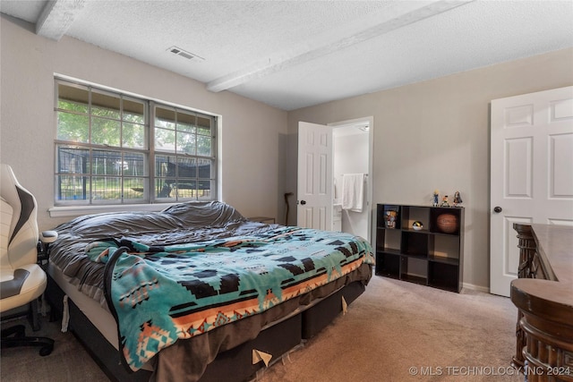 carpeted bedroom with beamed ceiling and a textured ceiling