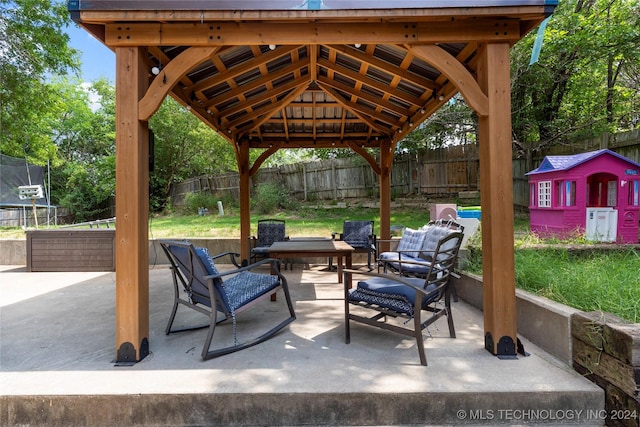 view of patio / terrace with a gazebo, an outdoor living space, an outbuilding, and a trampoline