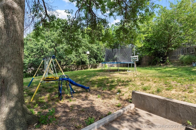 view of yard with a playground and a trampoline