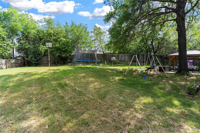 view of yard featuring a playground and a trampoline