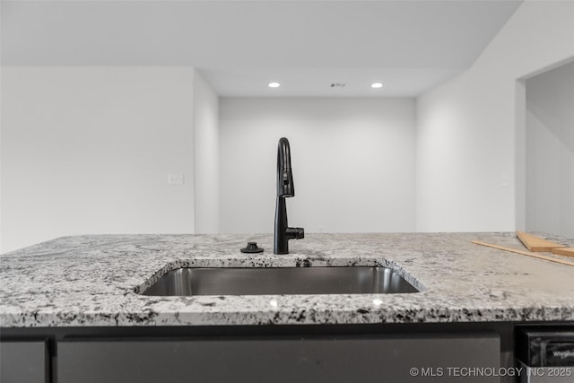 kitchen with light stone countertops and sink