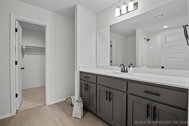 bathroom featuring a shower and vanity