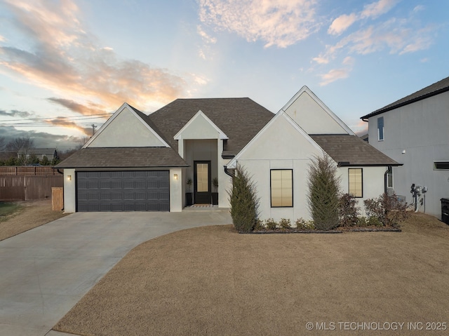 view of front of property with fence, a shingled roof, stucco siding, concrete driveway, and a garage