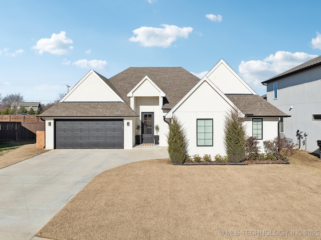 view of front of property with fence, concrete driveway, an attached garage, and a shingled roof