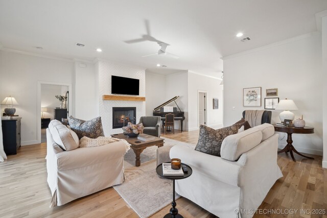 living room featuring light hardwood / wood-style floors, ceiling fan, crown molding, and sink