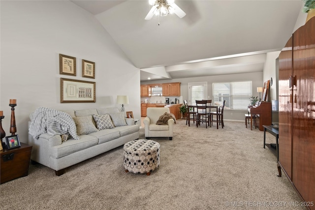 carpeted living room with ceiling fan and vaulted ceiling