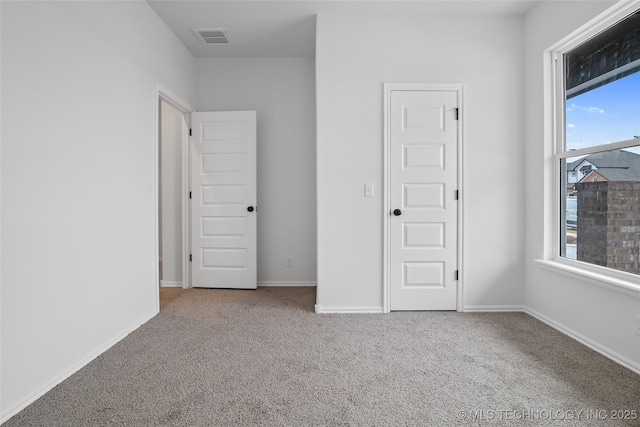 unfurnished bedroom featuring multiple windows and light carpet