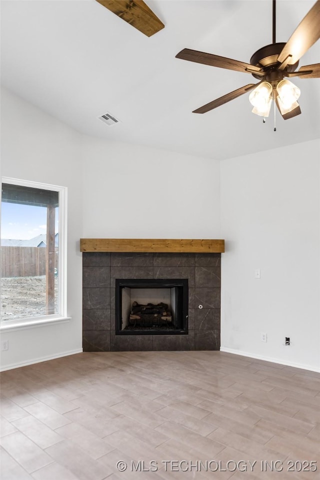 unfurnished living room with a tiled fireplace, light hardwood / wood-style flooring, and ceiling fan