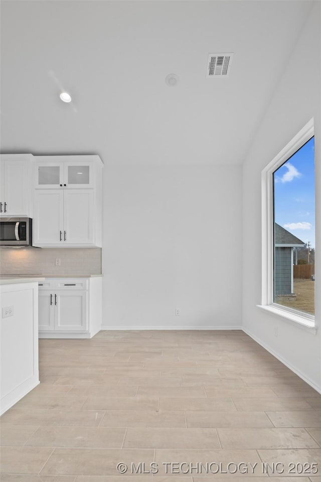 interior space featuring white cabinetry and tasteful backsplash