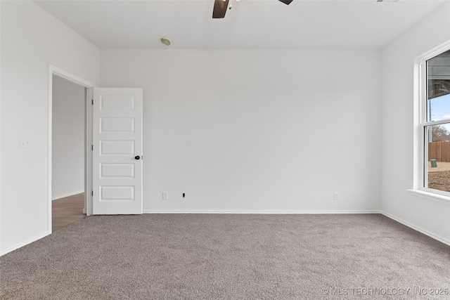 empty room with ceiling fan and carpet flooring