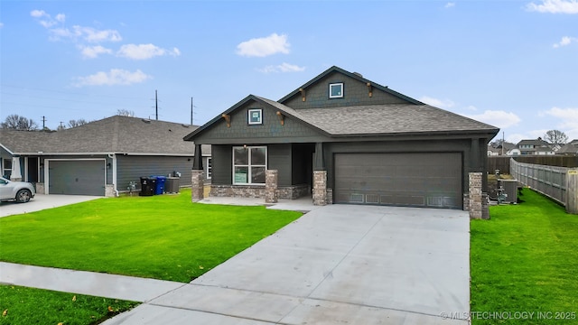 view of front of home featuring central AC unit, a garage, and a front yard