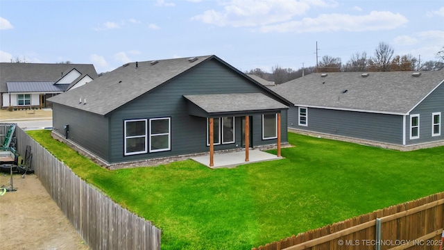 rear view of house featuring a patio area and a lawn