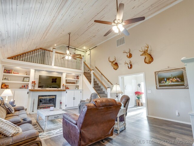 living room with ceiling fan, wood-type flooring, high vaulted ceiling, built in features, and wooden ceiling