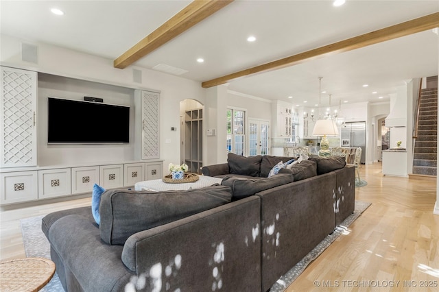 living room featuring beam ceiling, crown molding, and light hardwood / wood-style floors