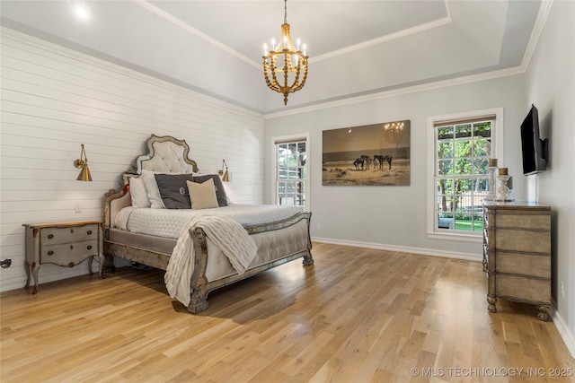 bedroom featuring a chandelier, hardwood / wood-style flooring, and a raised ceiling