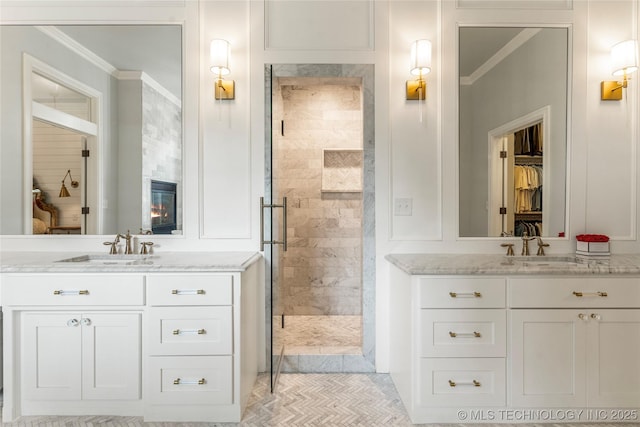 bathroom featuring tiled shower, vanity, and ornamental molding