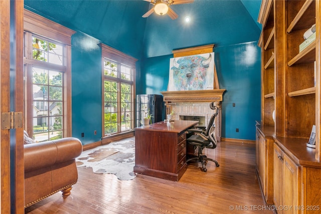 office space with a wealth of natural light, ceiling fan, and light hardwood / wood-style flooring