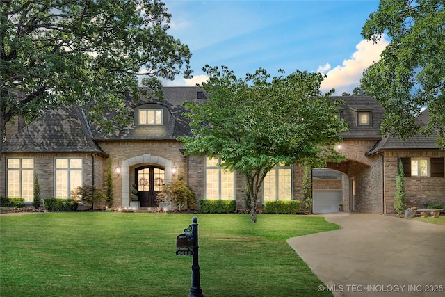 french country home featuring french doors and a lawn