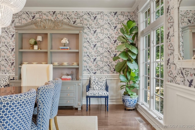 dining space featuring built in features, dark wood-type flooring, and ornamental molding