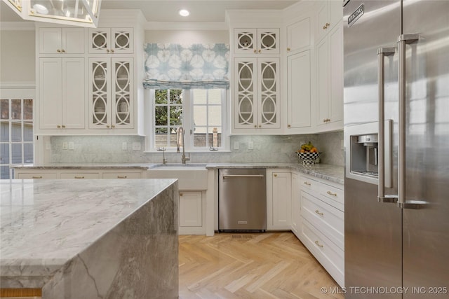 kitchen featuring sink, white cabinets, decorative light fixtures, and appliances with stainless steel finishes