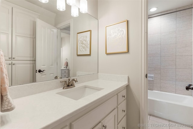 bathroom featuring tile patterned flooring, vanity, and tiled shower / bath combo